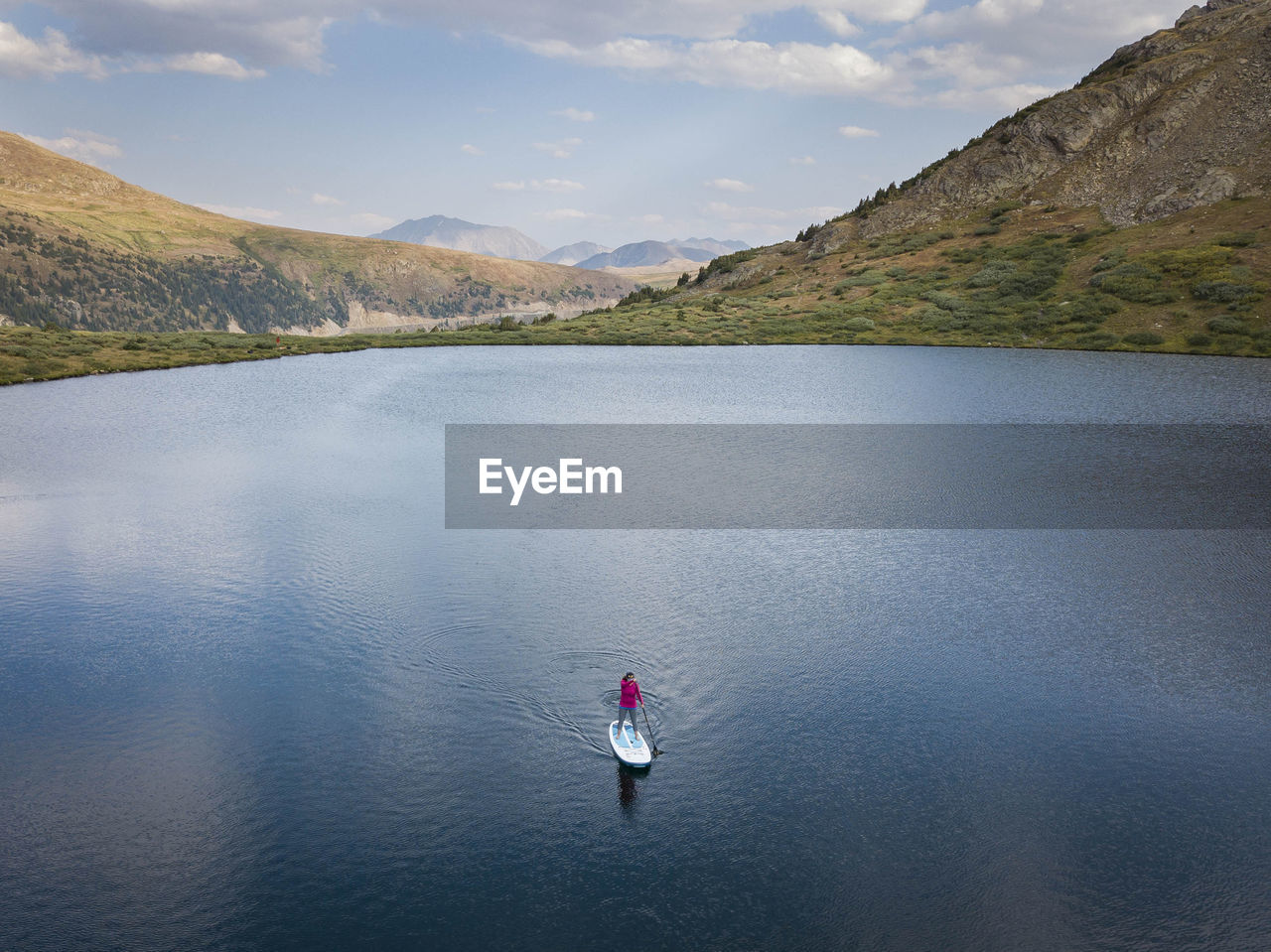 Aerial view of woman paddleboarding in lake