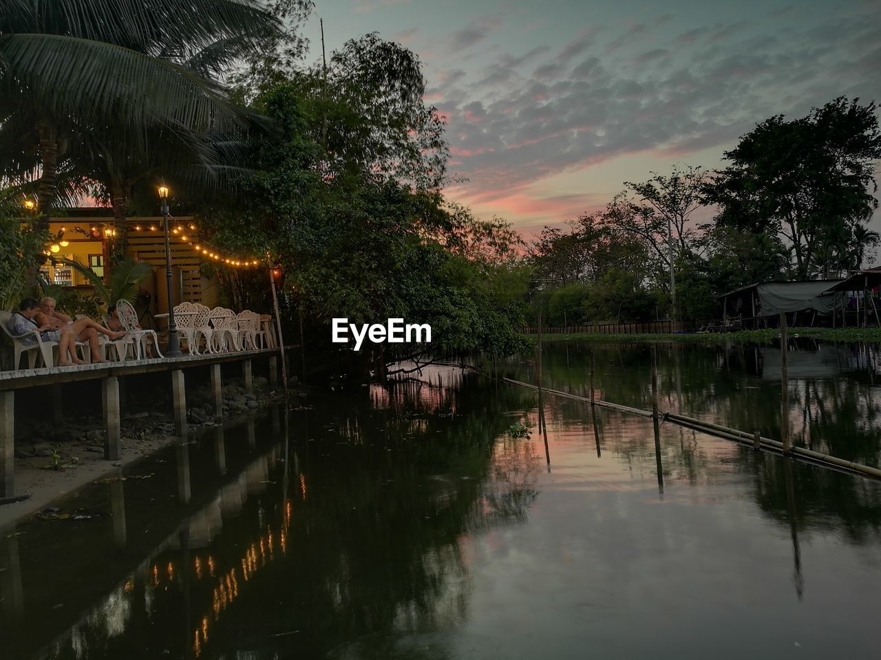 REFLECTION OF TREES IN WATER AGAINST SKY AT SUNSET