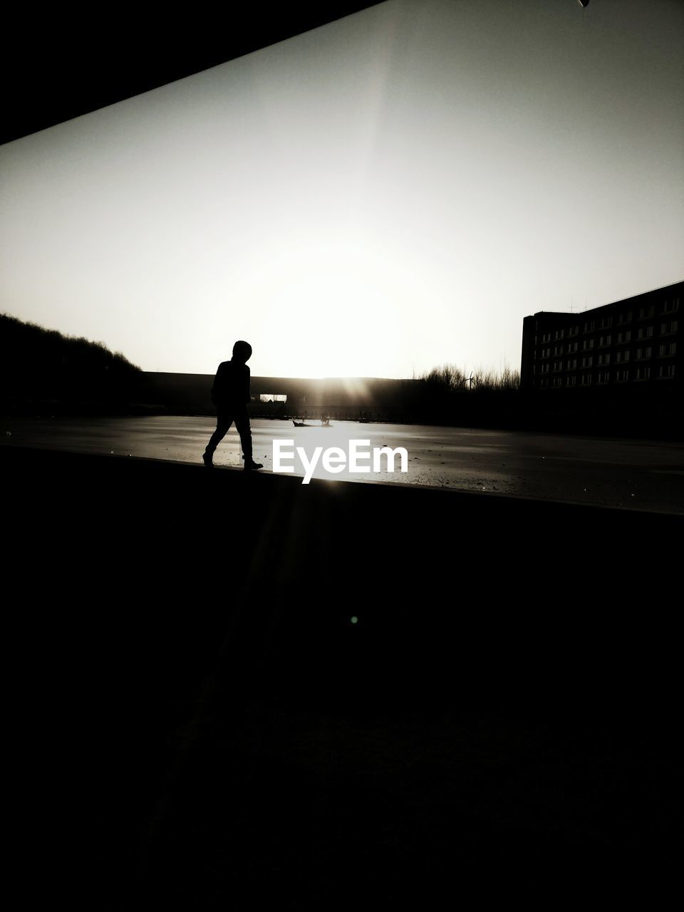 SILHOUETTE MAN ON SHORE AGAINST SKY