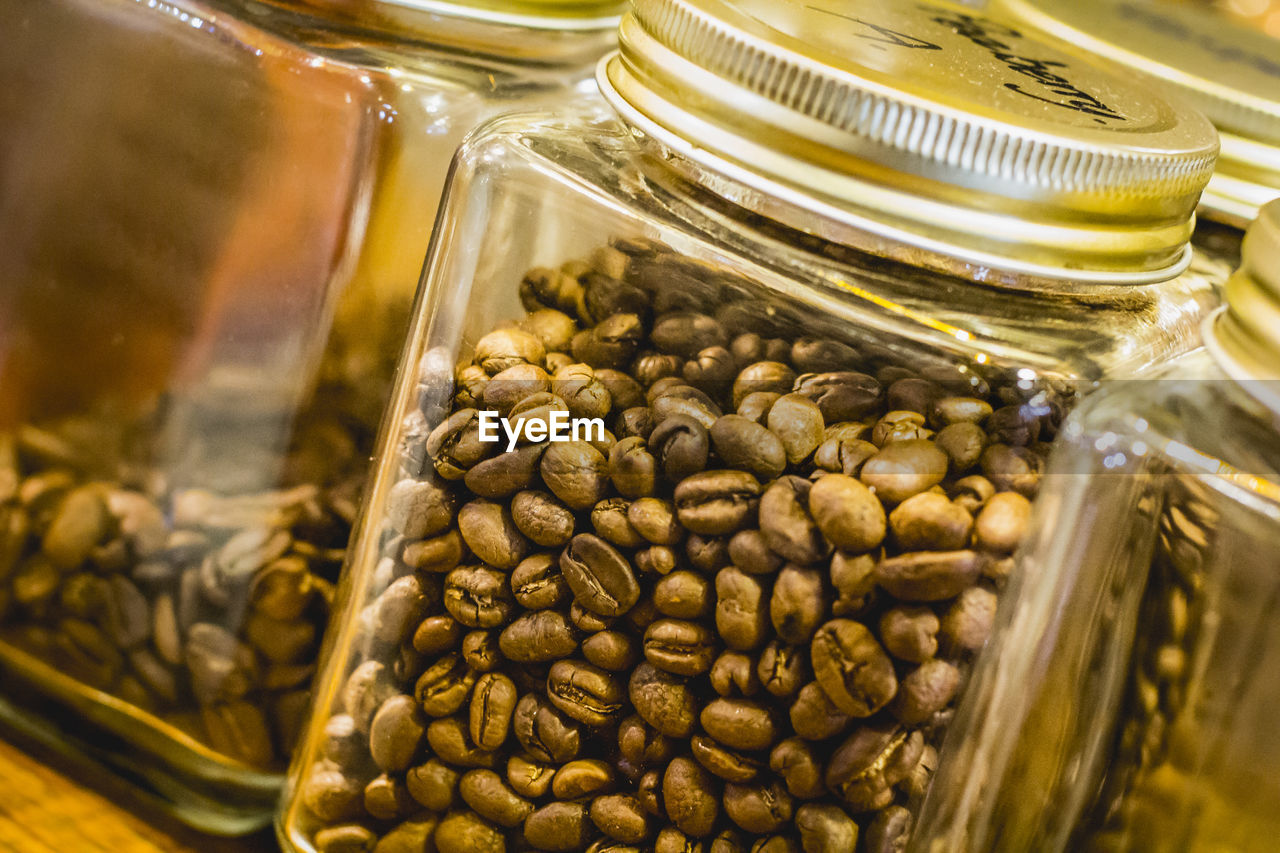 Close-up of roasted coffee beans in mason jar at table