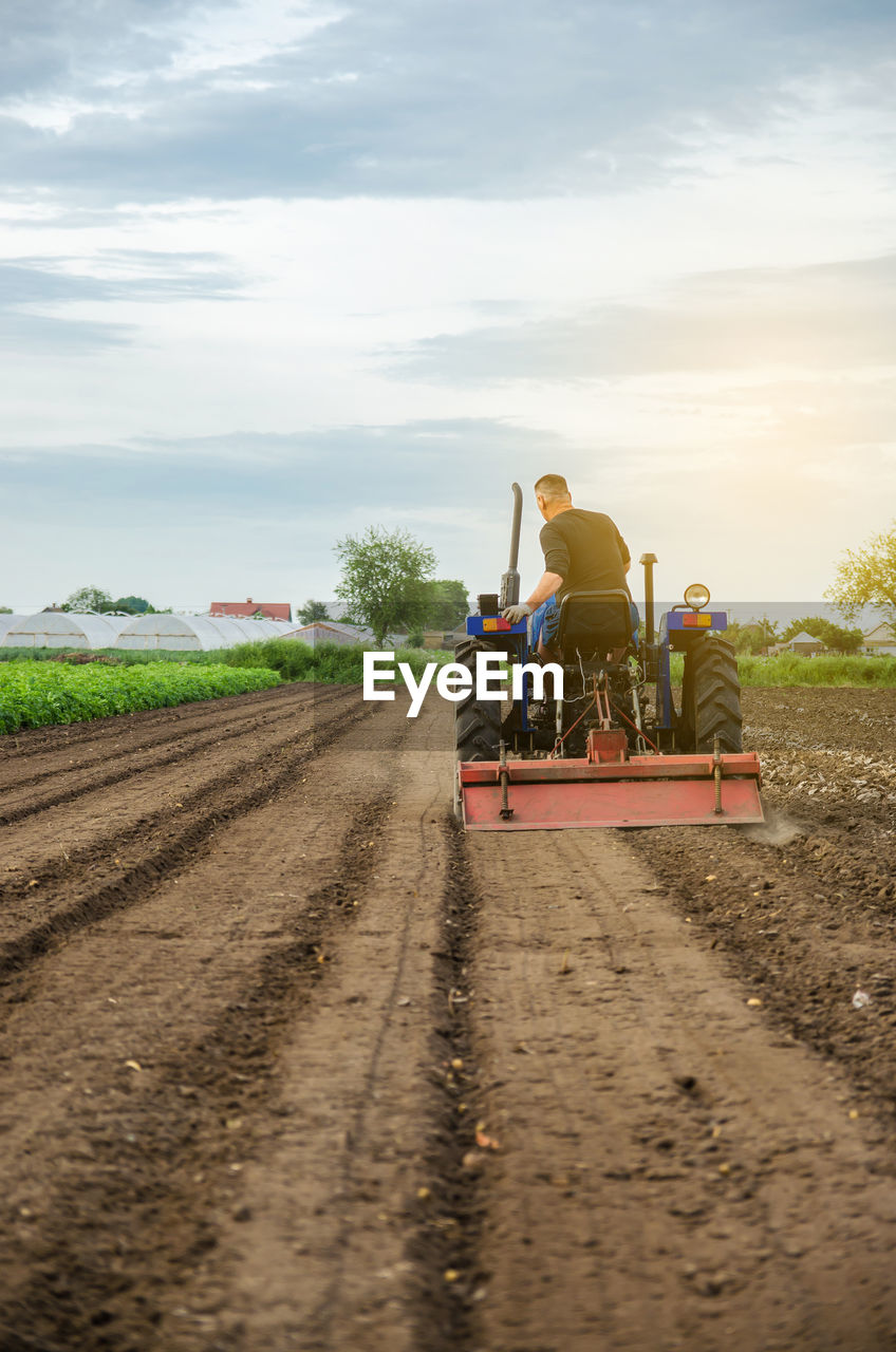 A farmer grinds up solid soil to plant new crops. development of agricultural economy