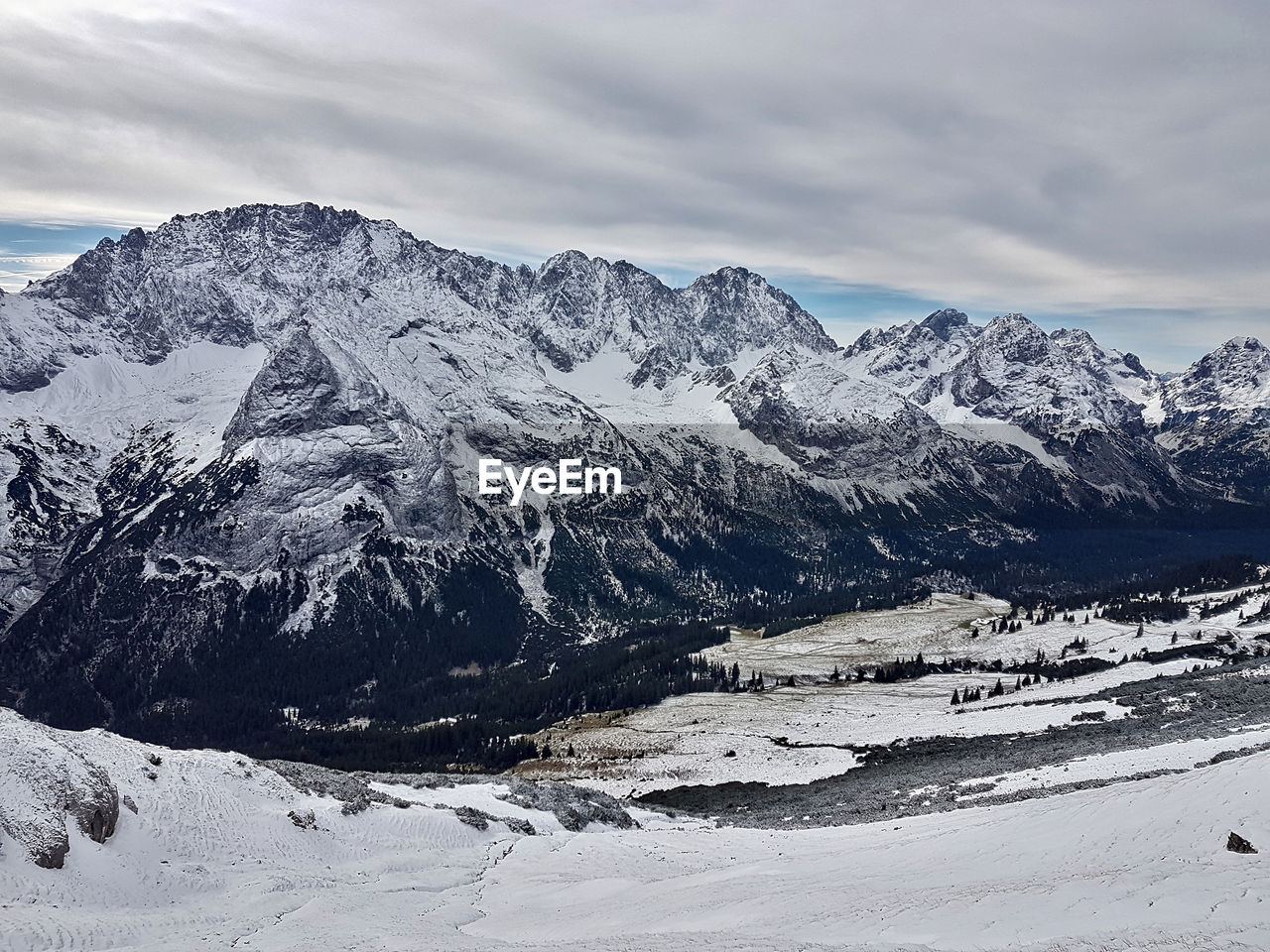 Scenic view of snowcapped mountains against cloudy sky
