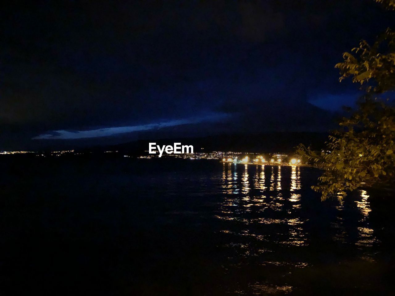 ILLUMINATED SEA AGAINST SKY AT NIGHT