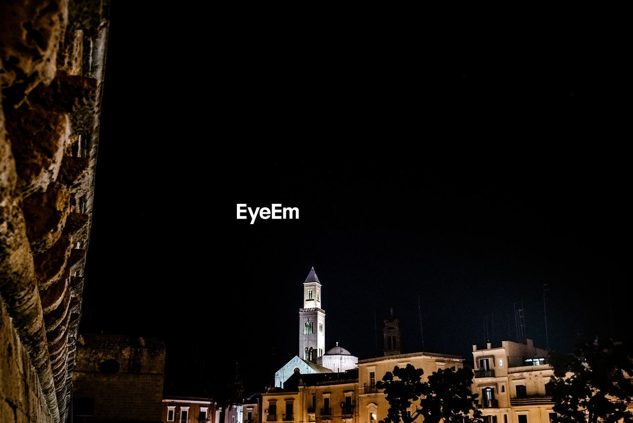 LOW ANGLE VIEW OF BUILDINGS IN CITY AT NIGHT