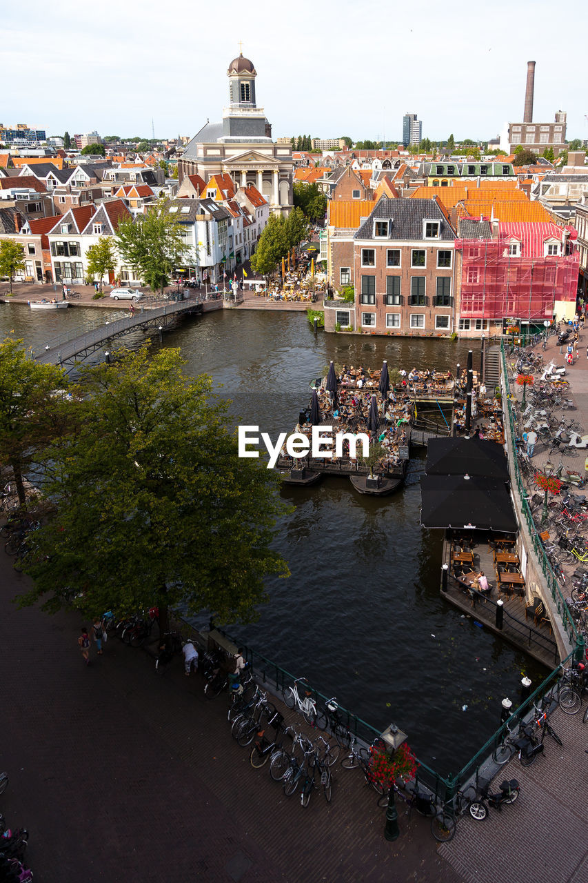 HIGH ANGLE VIEW OF PEOPLE ON CANAL BY BUILDINGS IN TOWN