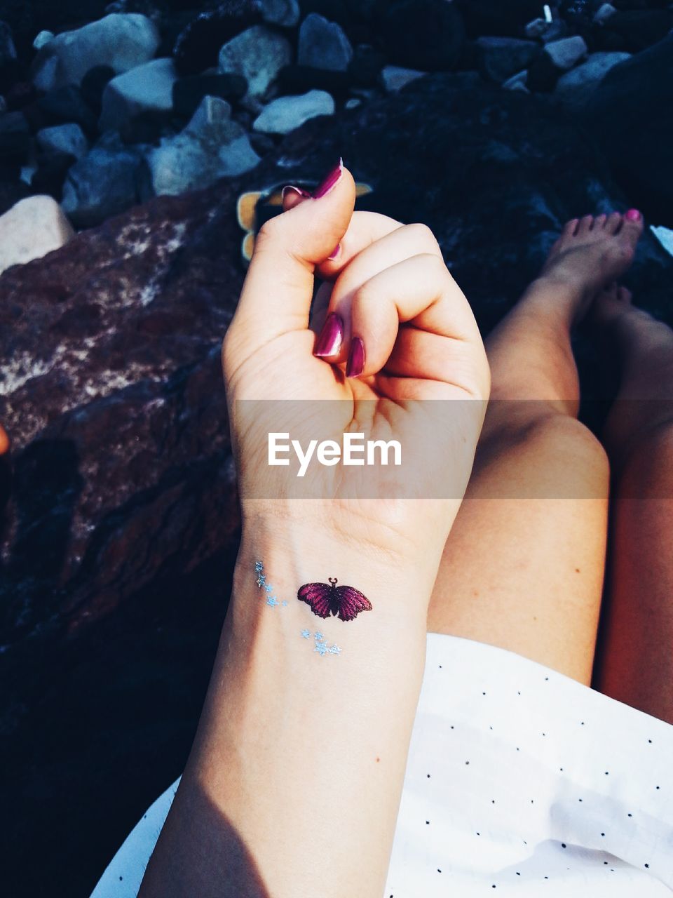 Cropped image of woman showing butterfly tattoo