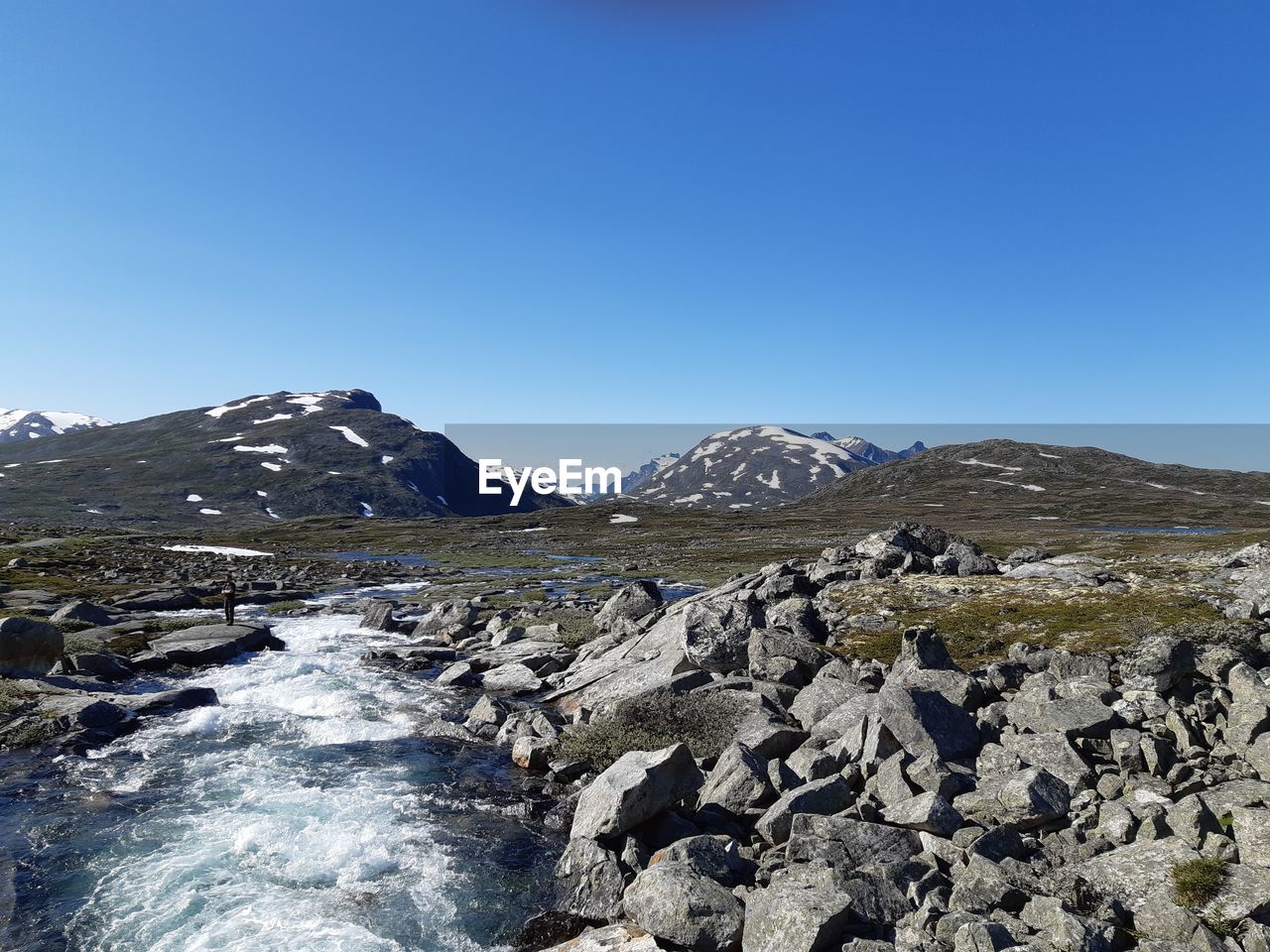 Scenic view of snowcapped mountains against clear blue sky