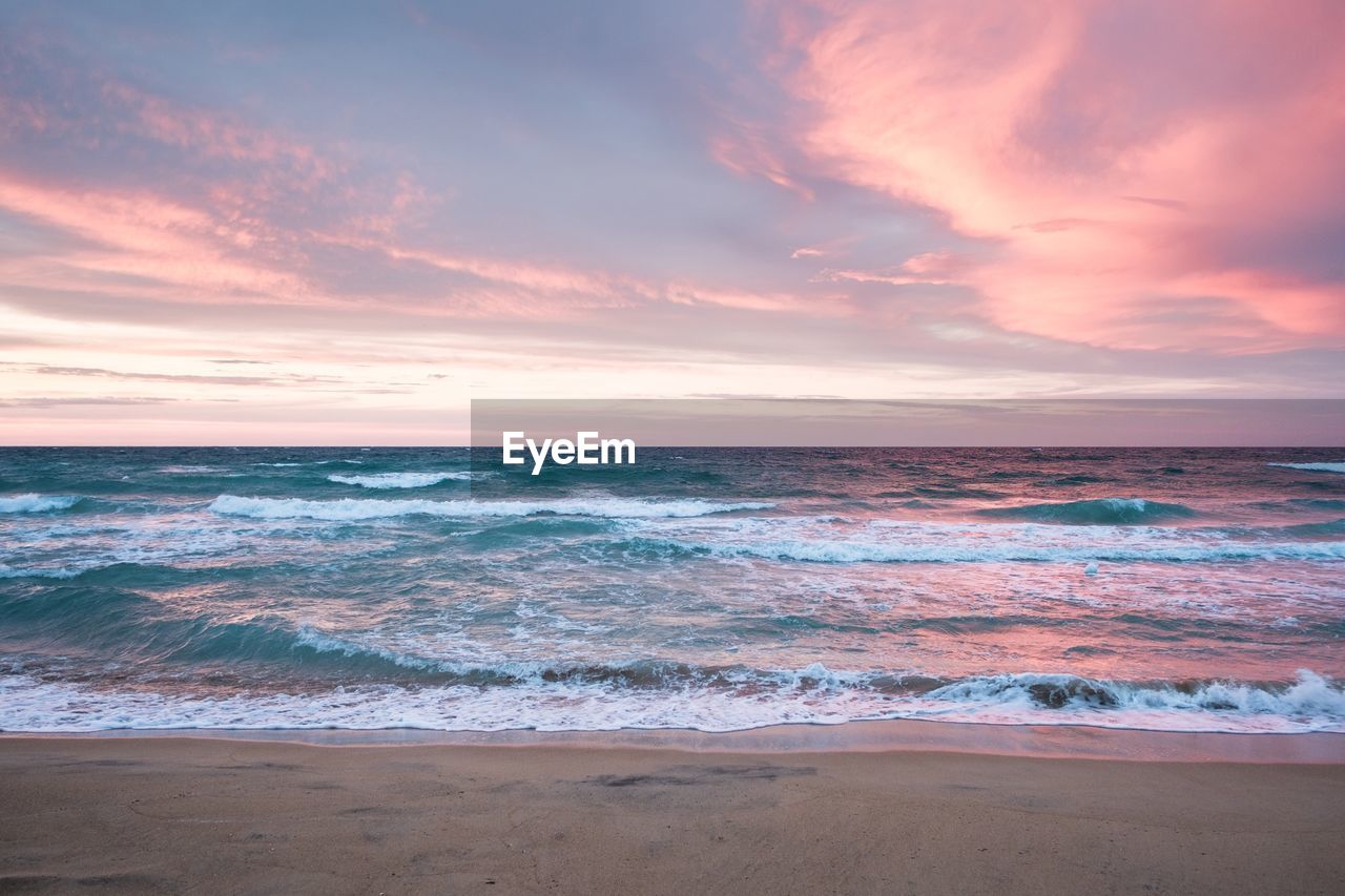 Scenic view of beach against sky during sunset