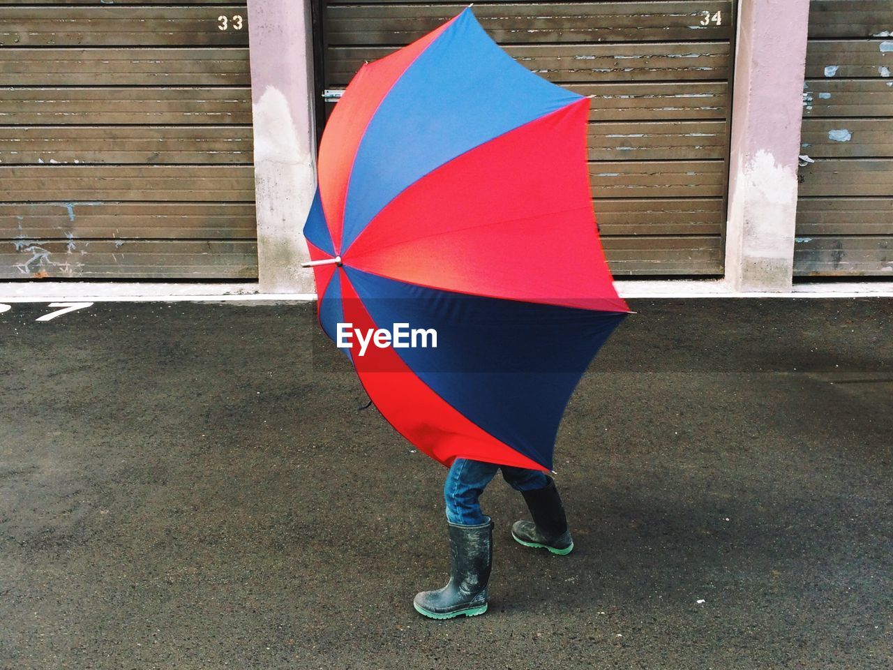 Child shelter under umbrella on road