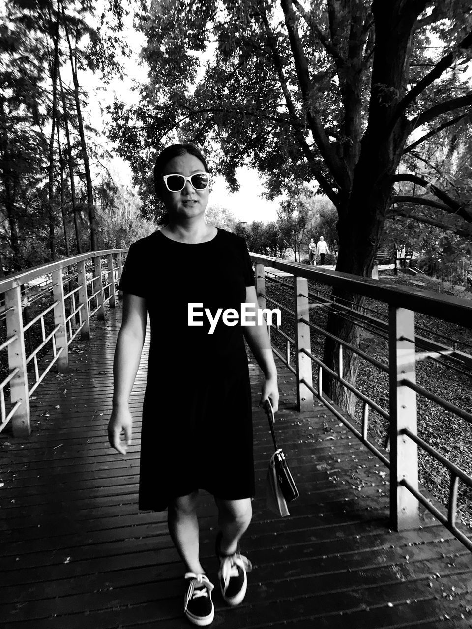 Portrait of woman walking on footbridge