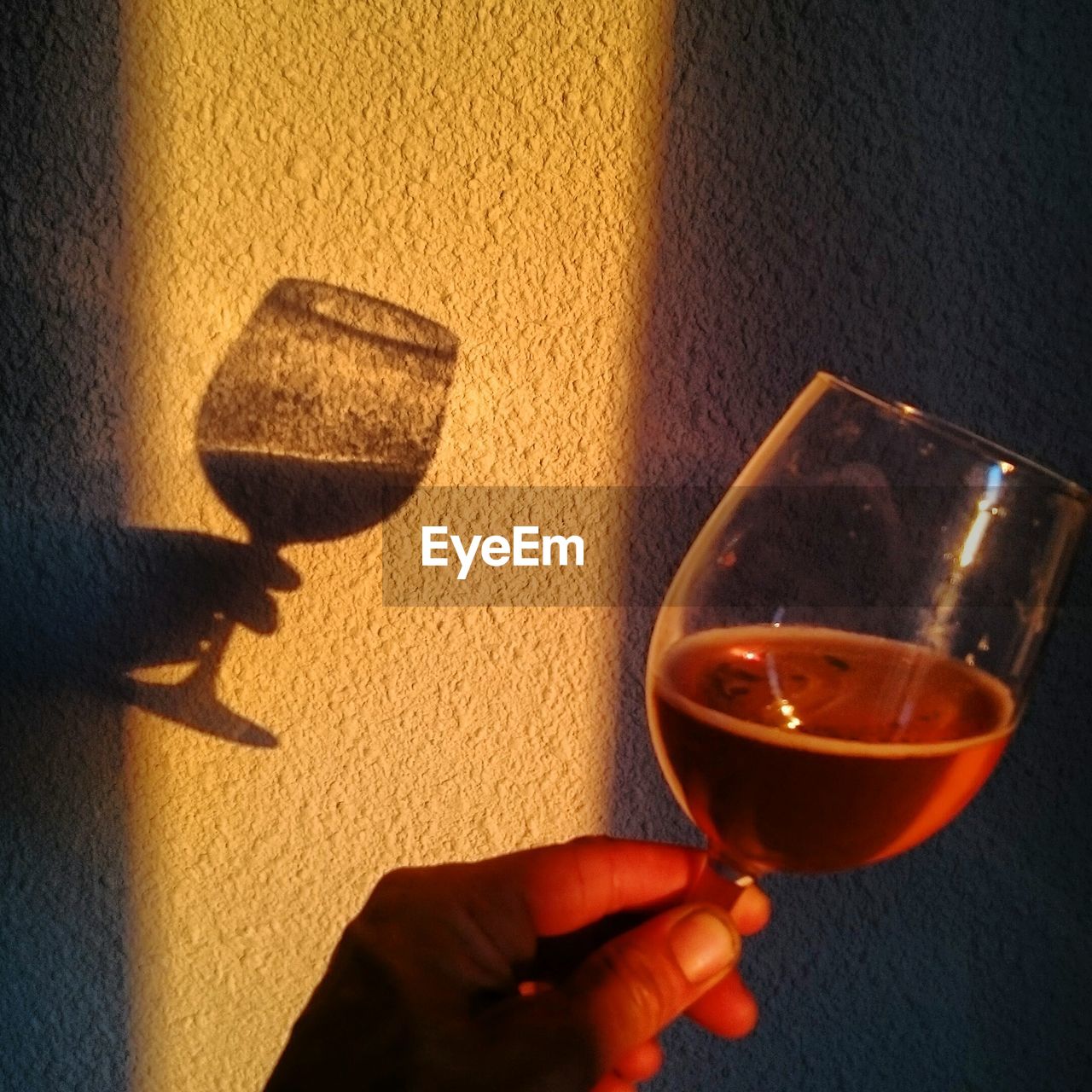 CLOSE-UP OF HAND HOLDING GLASS OF WINE