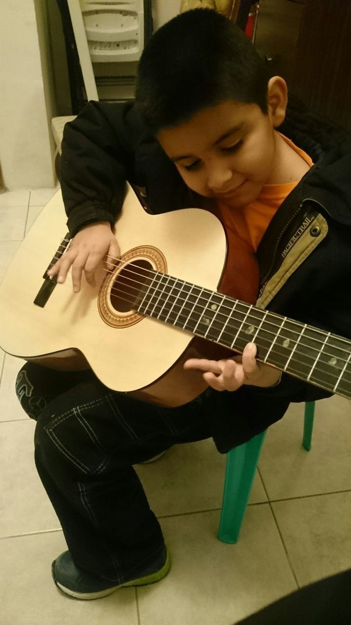 YOUNG MAN PLAYING GUITAR IN STUDIO