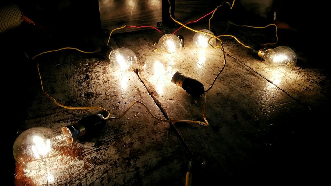 Illuminated light bulbs on floor in darkroom