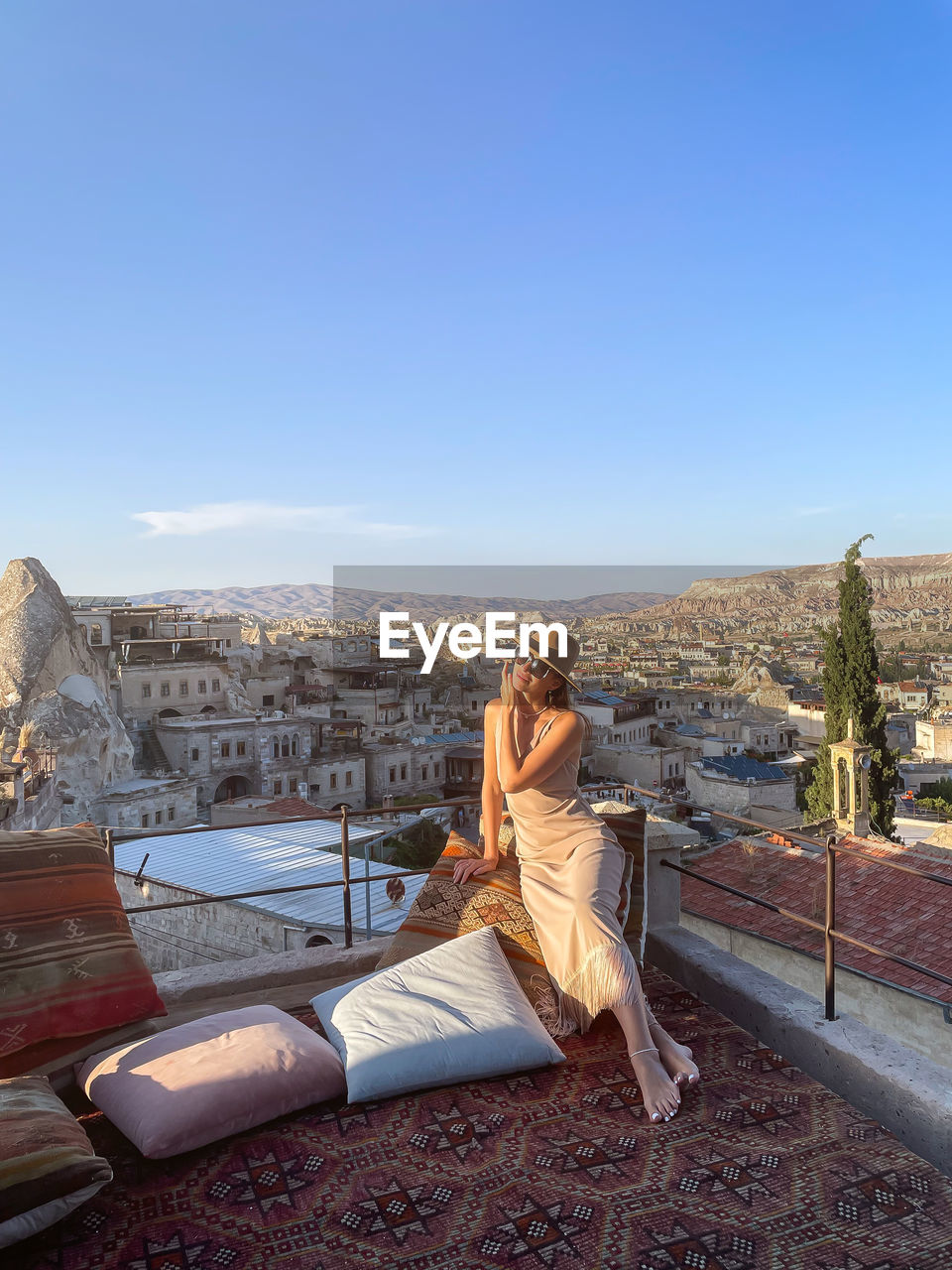 rear view of woman sitting on field against clear sky