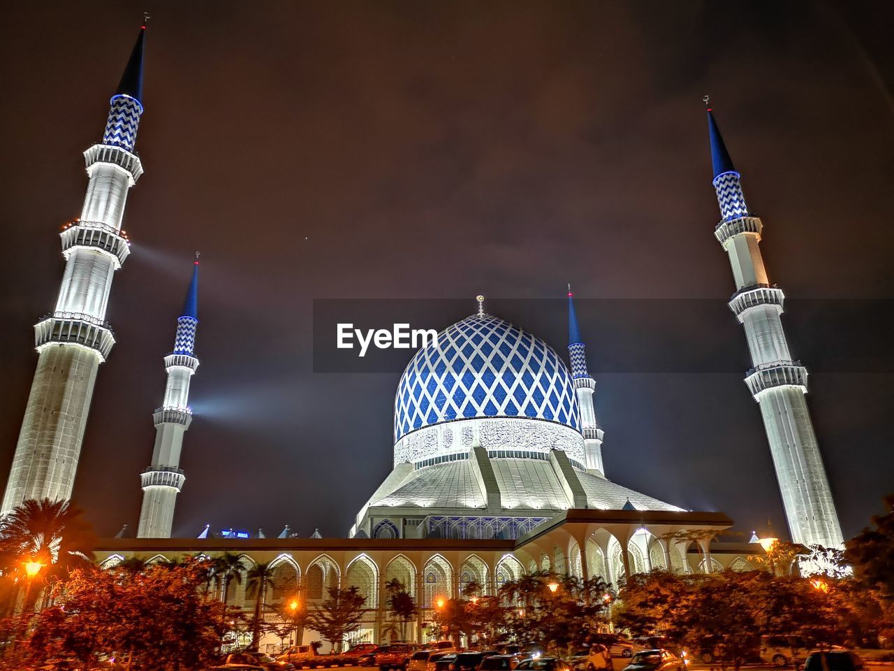 Illuminated  mosque against sky at night