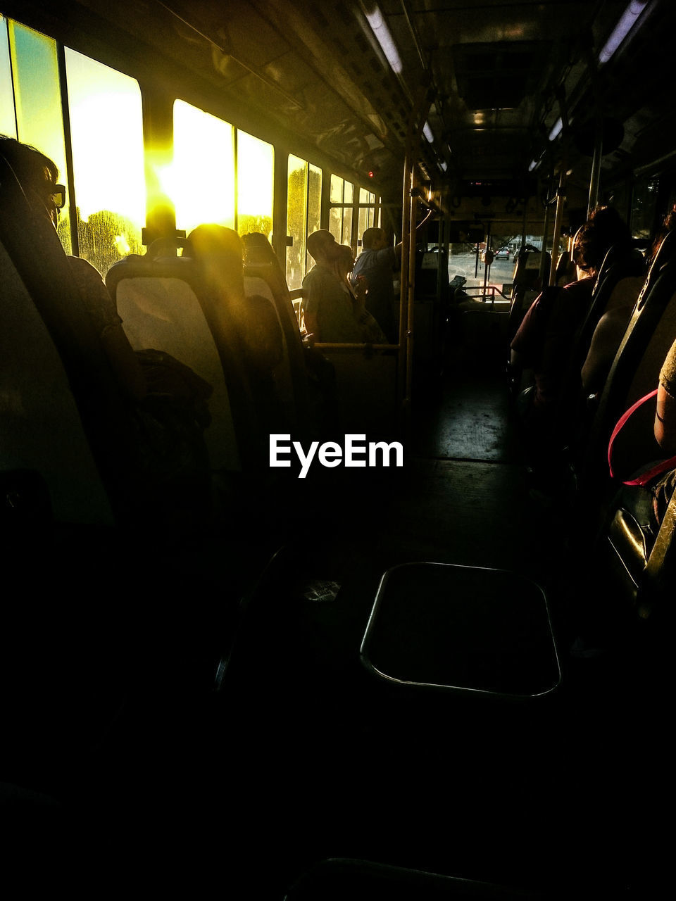 Commuters traveling in bus during sunset