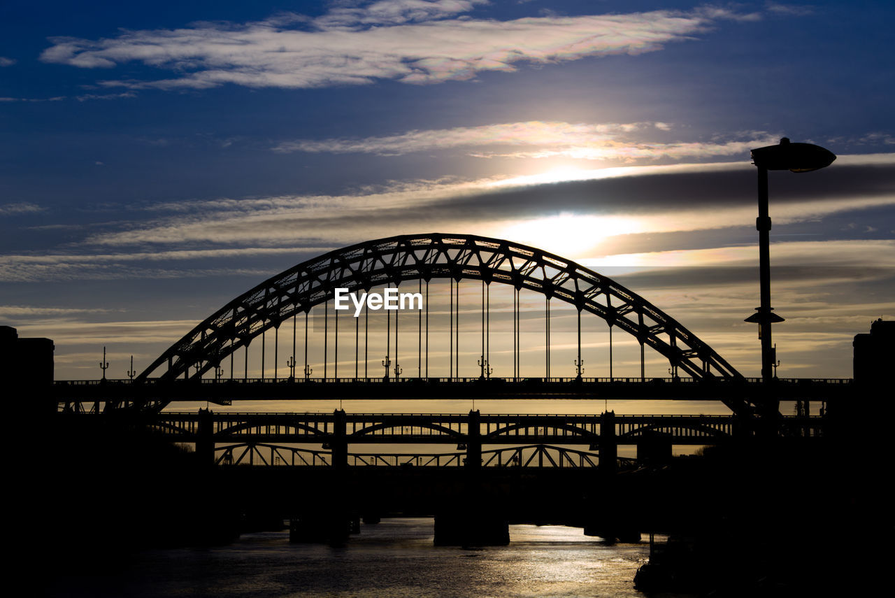 bridge over river against sky during sunset