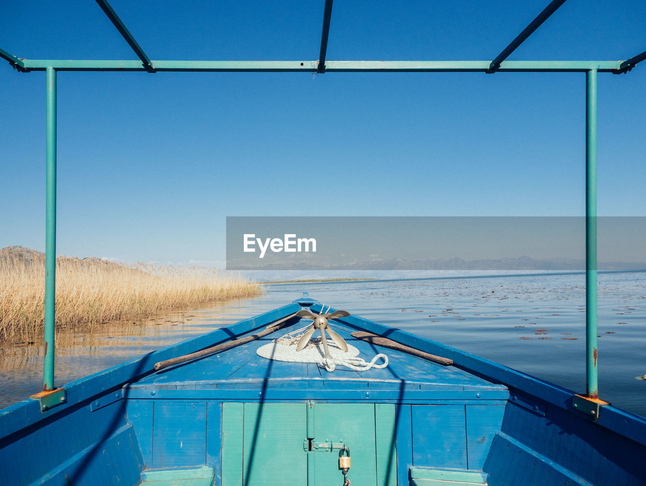 Scenic view of lake against clear blue sky