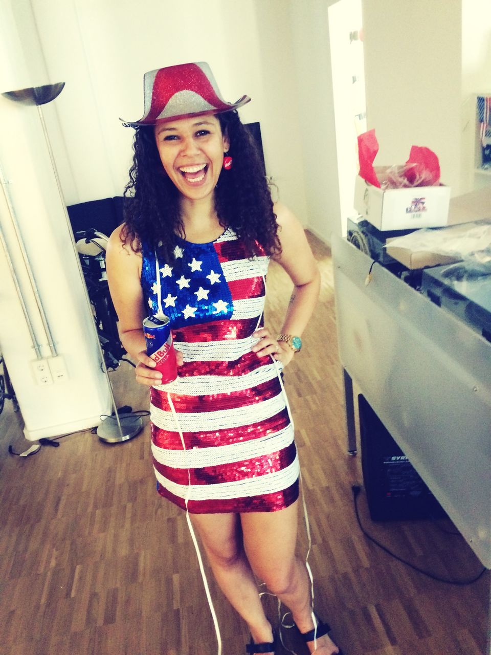 Portrait of cheerful young woman dressed in american flag at home
