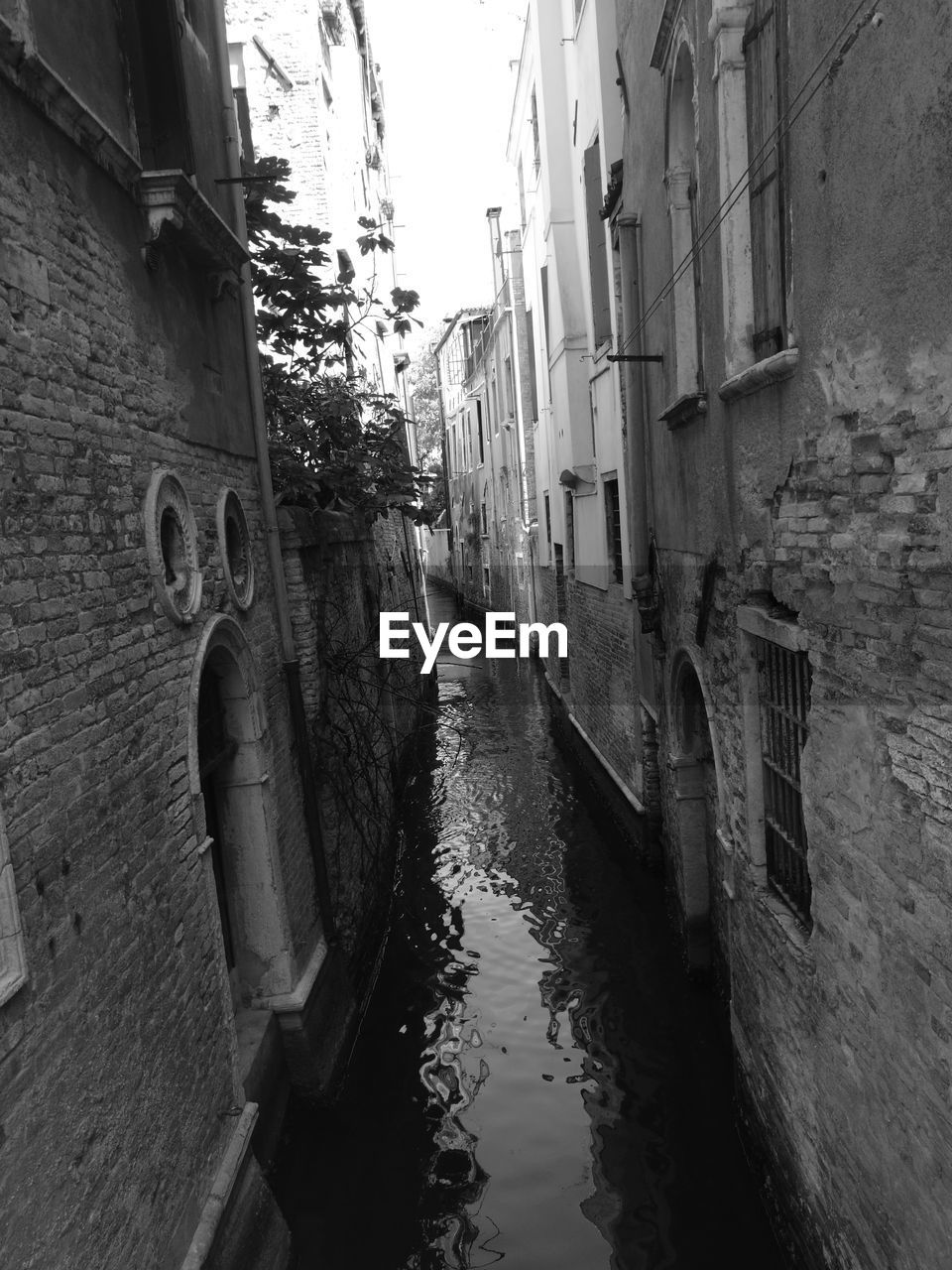 VIEW OF NARROW CANAL ALONG BUILDINGS