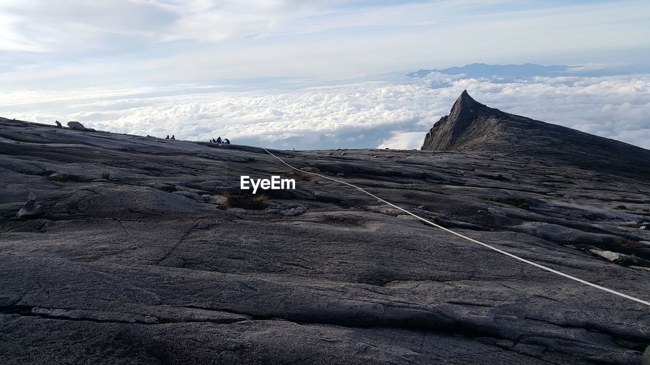 View of rope on rocky mountain against sky