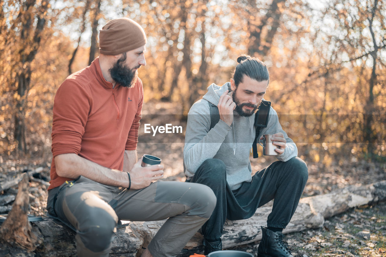 MAN SITTING IN FOREST