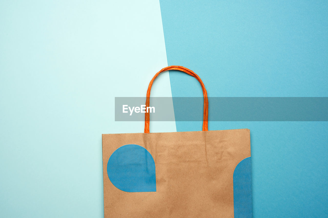 Directly above shot of paper bag over blue background