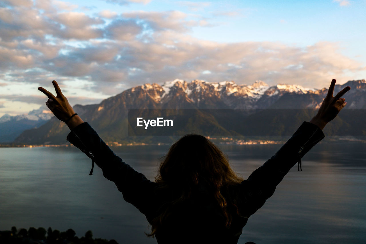 Rear view of woman looking at lake during winter