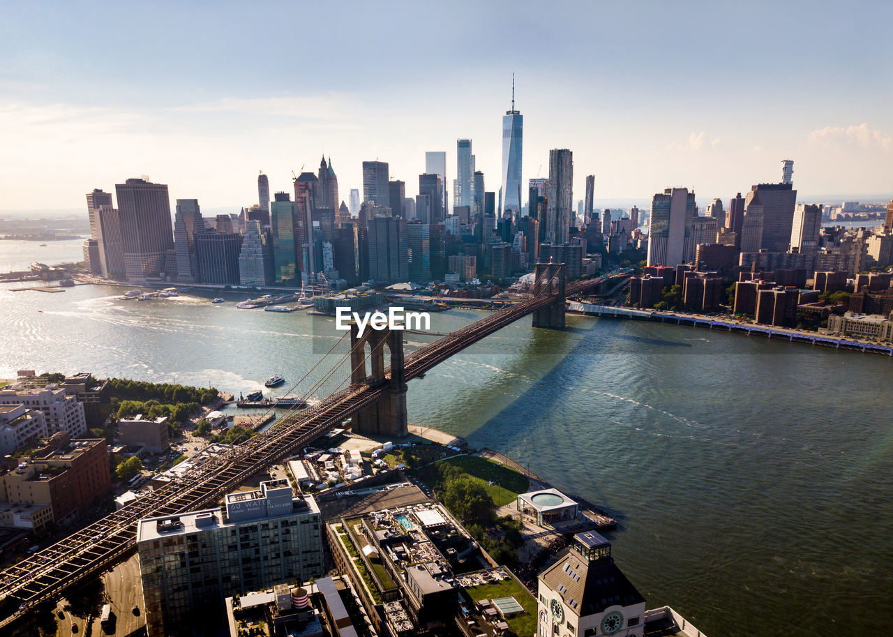 Aerial view of brooklyn bridge over river in city against sky