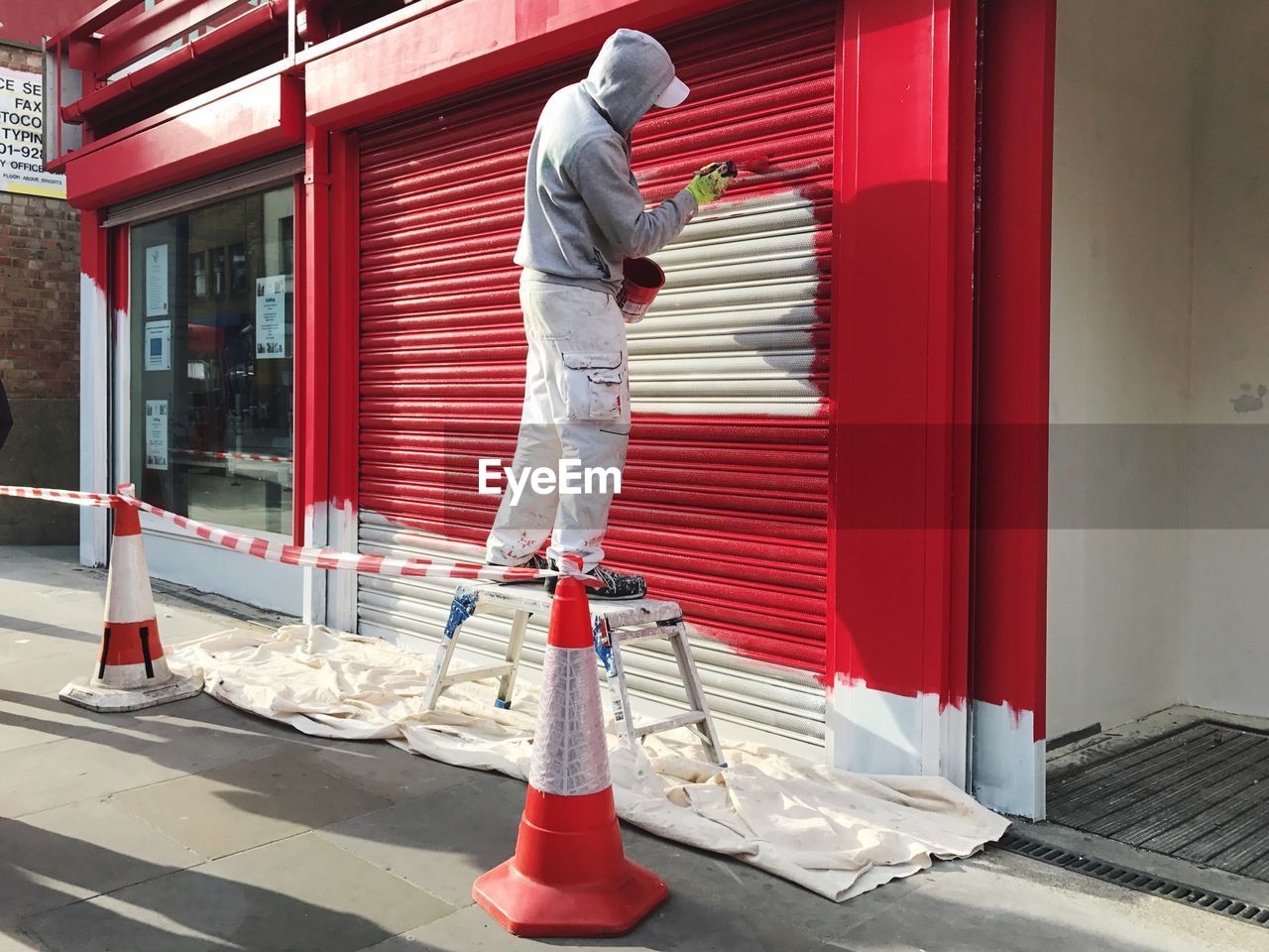 FULL LENGTH OF MAN WORKING ON RED STRUCTURE