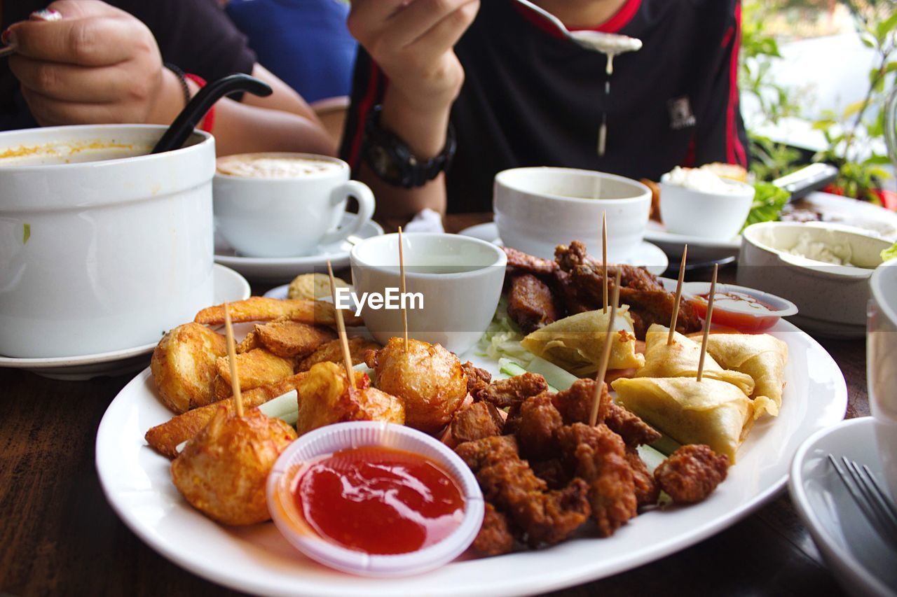 Close-up mid section of people eating food