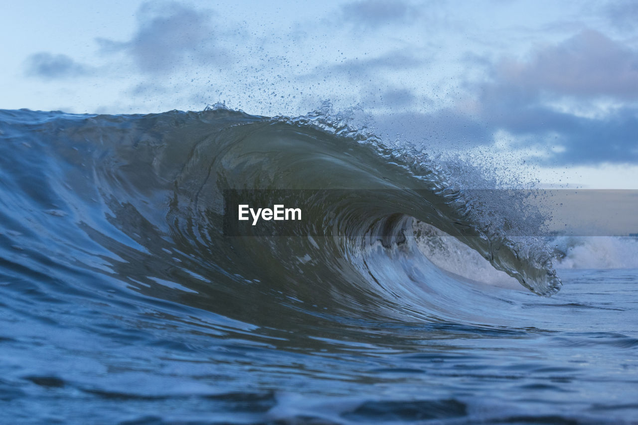 Close-up of sea waves splashing against sky