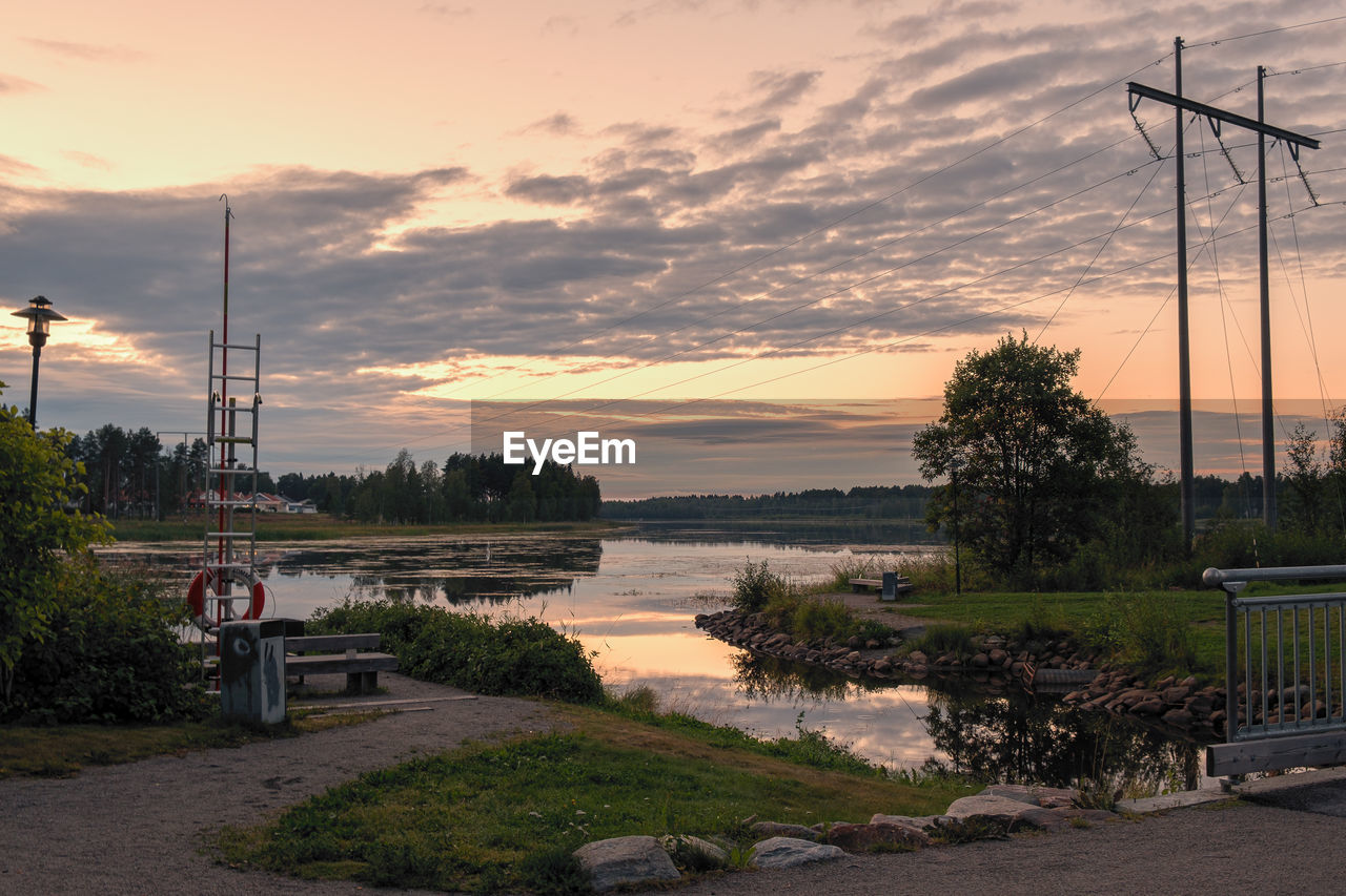 SCENIC VIEW OF LAKE BY TREES AGAINST SKY DURING SUNSET