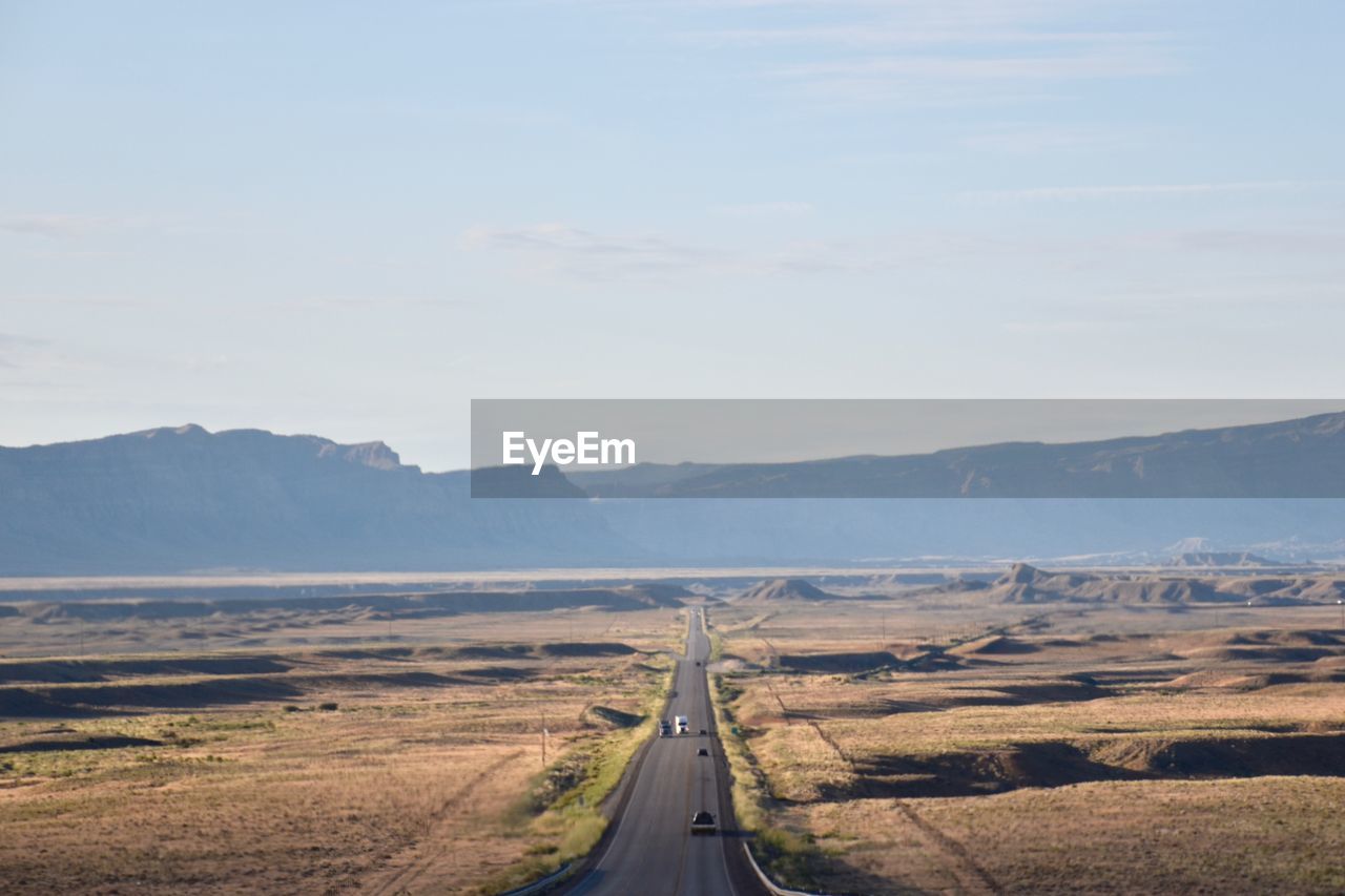 Road leading towards mountains against sky