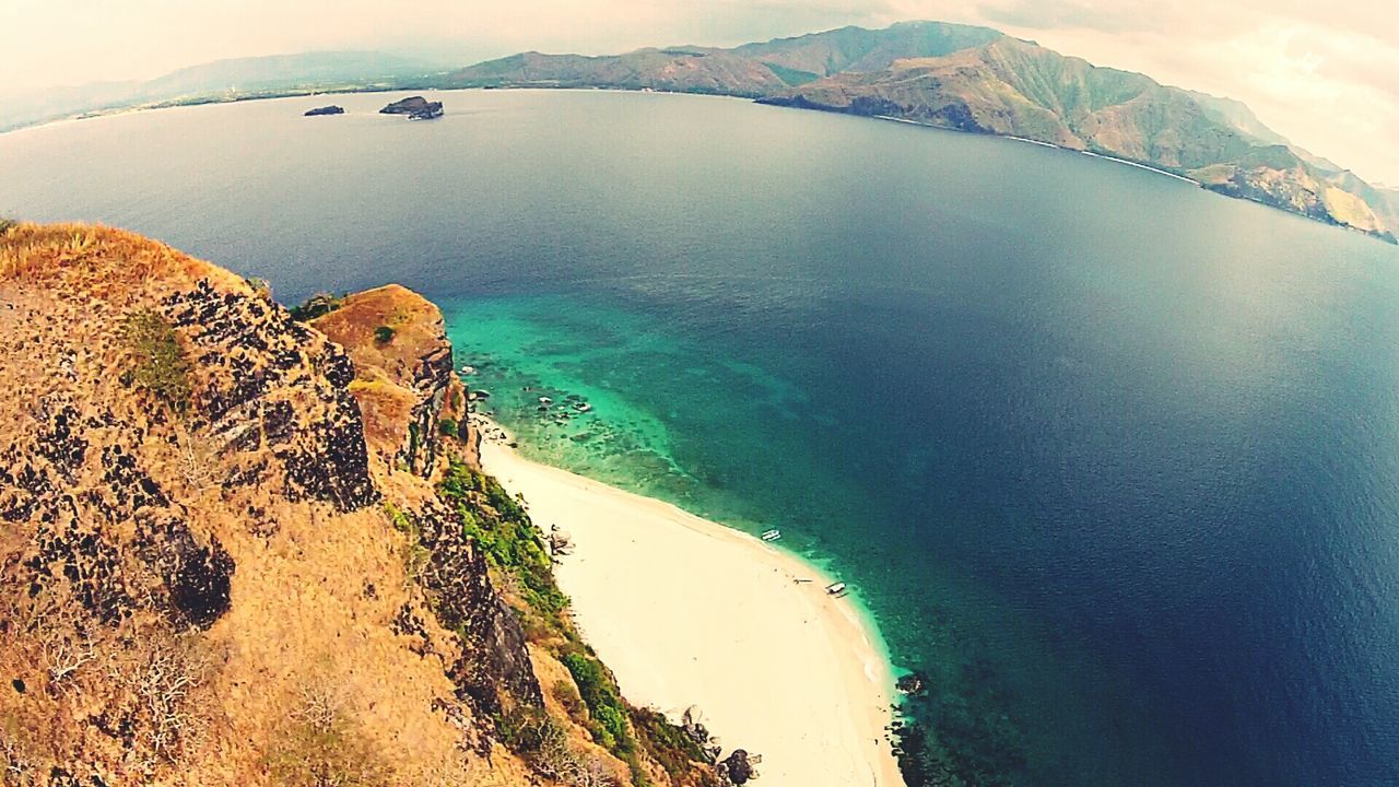 SCENIC VIEW OF SEA WITH MOUNTAIN RANGE IN BACKGROUND