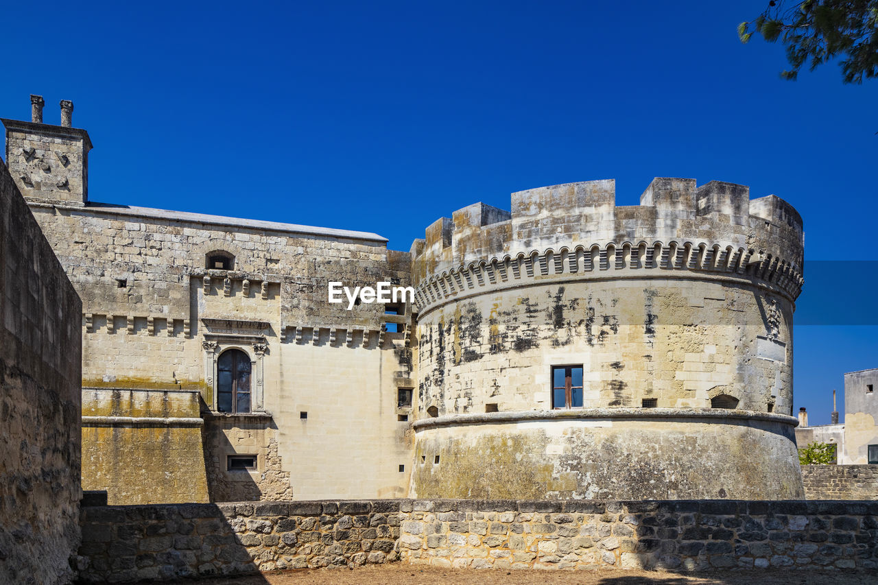 LOW ANGLE VIEW OF HISTORIC BUILDING AGAINST CLEAR BLUE SKY