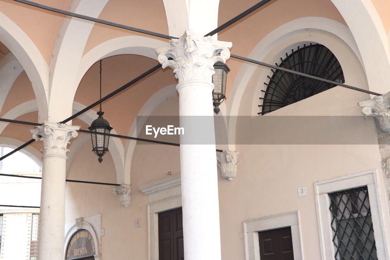 LOW ANGLE VIEW OF LAMP ON BUILDING BY WHITE WALL