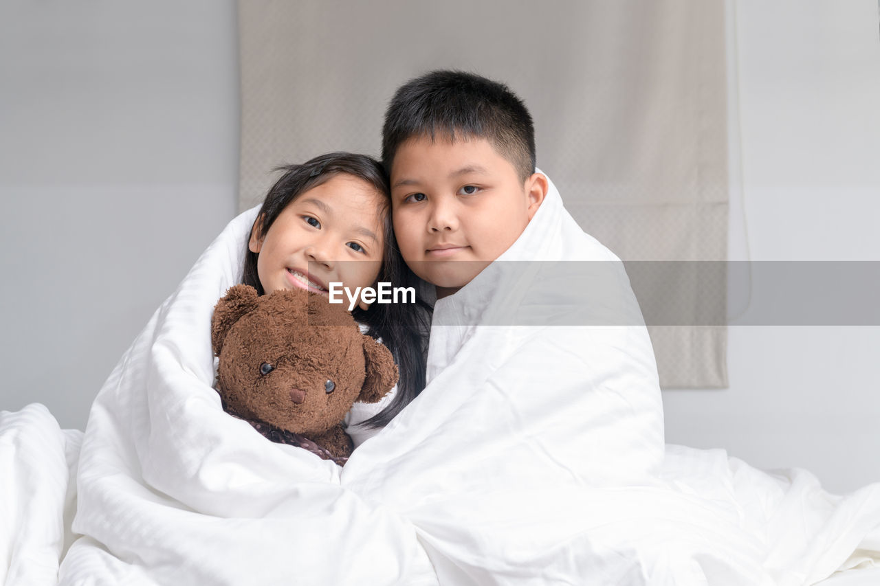 PORTRAIT OF CUTE BOY WITH TOY ON BED