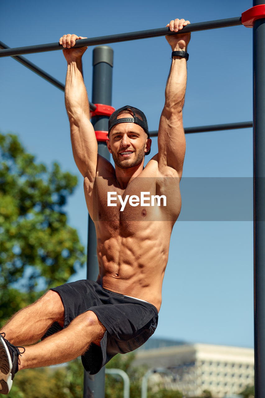 rear view of man exercising in gym against sky