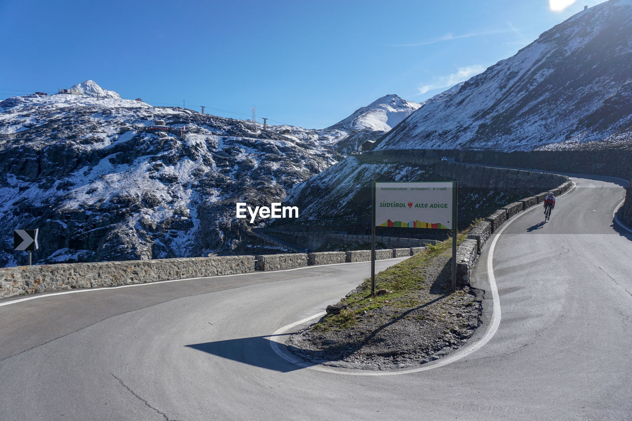 ROAD BY SNOWCAPPED MOUNTAIN AGAINST SKY