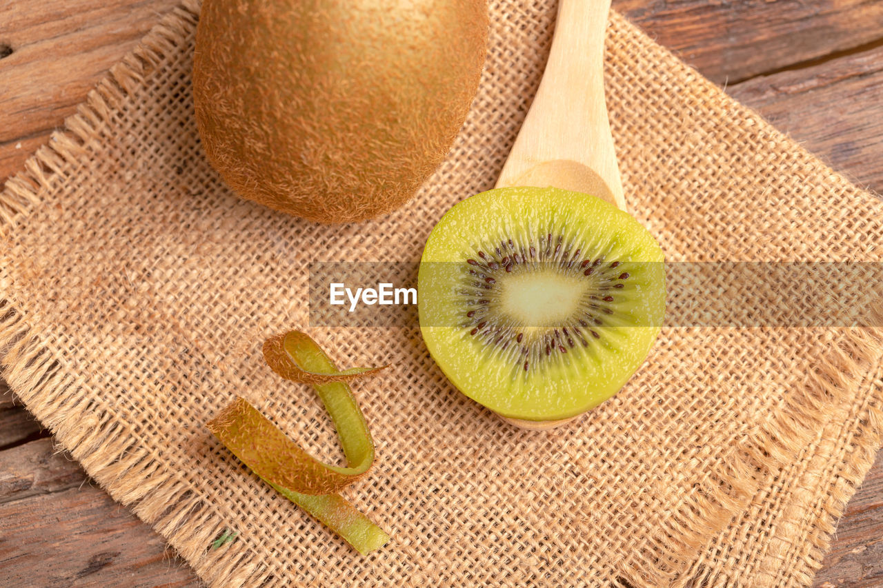 Top view of a sweet kiwi slice placed on the wood spoon