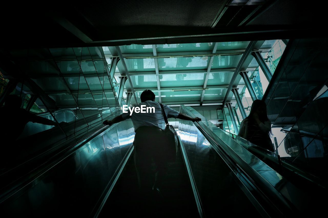 Low angle view of man on escalator