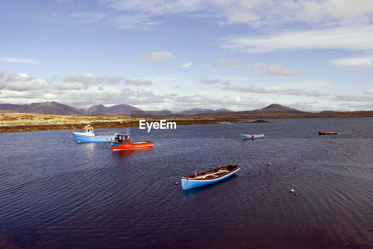 Boats moored on sea against sky