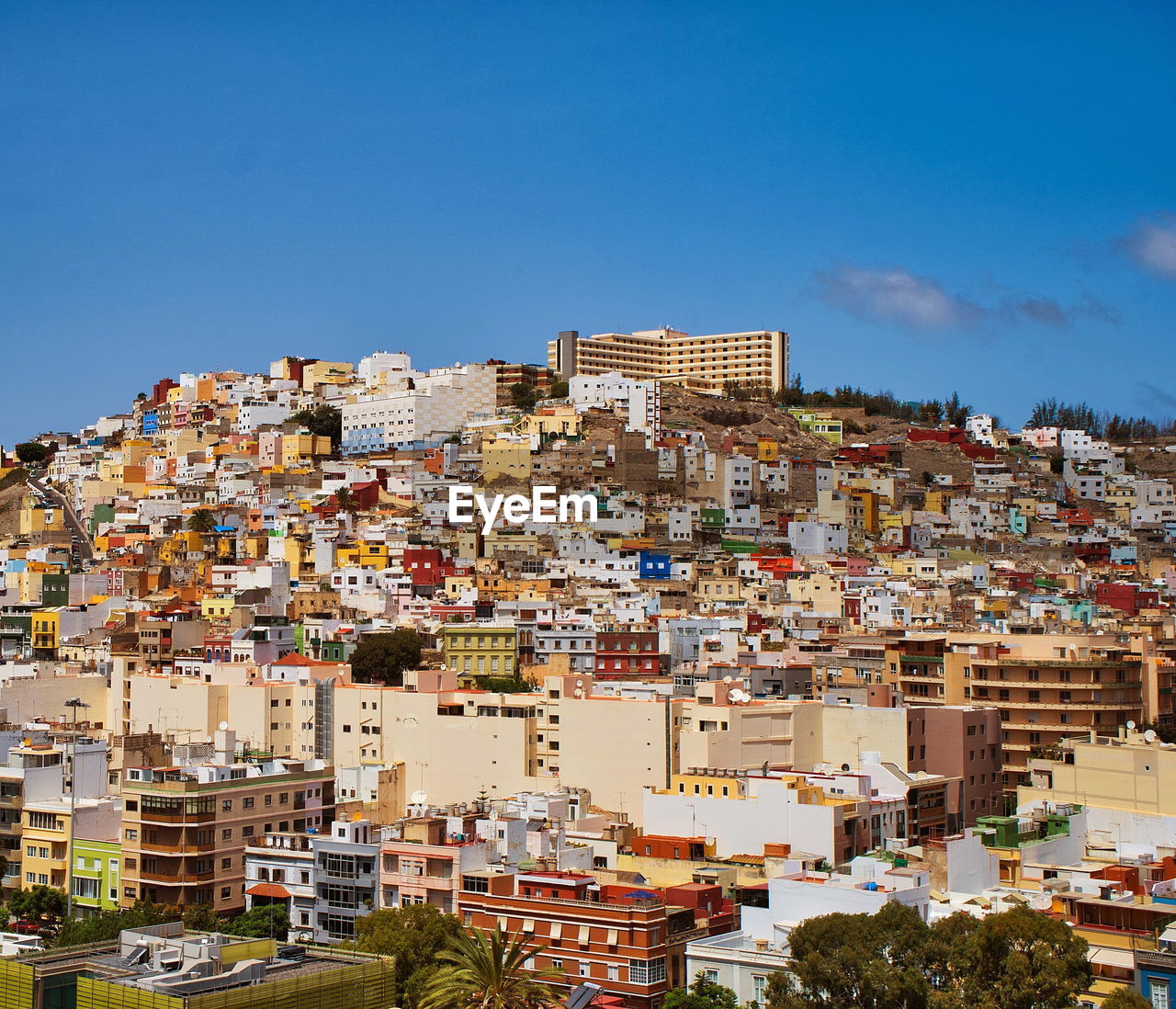 Buildings in city against clear blue sky