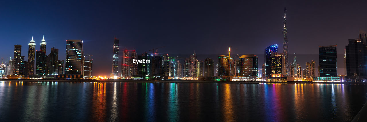 Illuminated buildings against sky at night