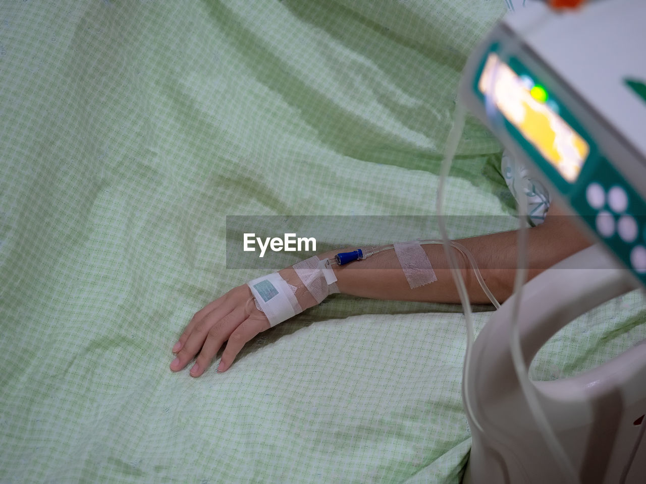 High angle view of woman with medical equipment on bed in hospital