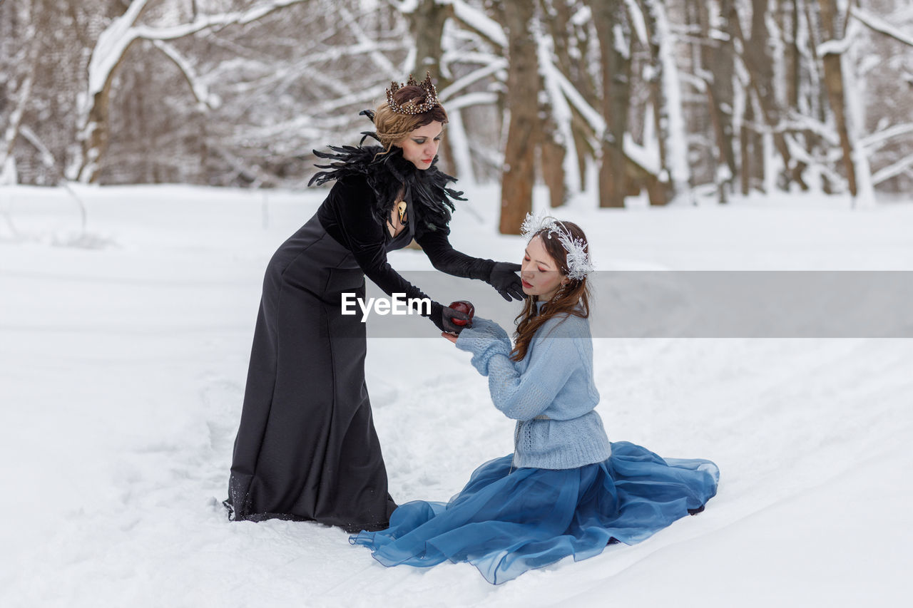 winter, cold temperature, snow, women, adult, two people, female, clothing, nature, emotion, togetherness, tree, child, warm clothing, white, footwear, positive emotion, childhood, family, freezing, happiness, land, smiling, fun, love, lifestyles, young adult, leisure activity, environment, plant, forest, full length, dress, bonding, enjoyment, beauty in nature, outdoors, men, frozen