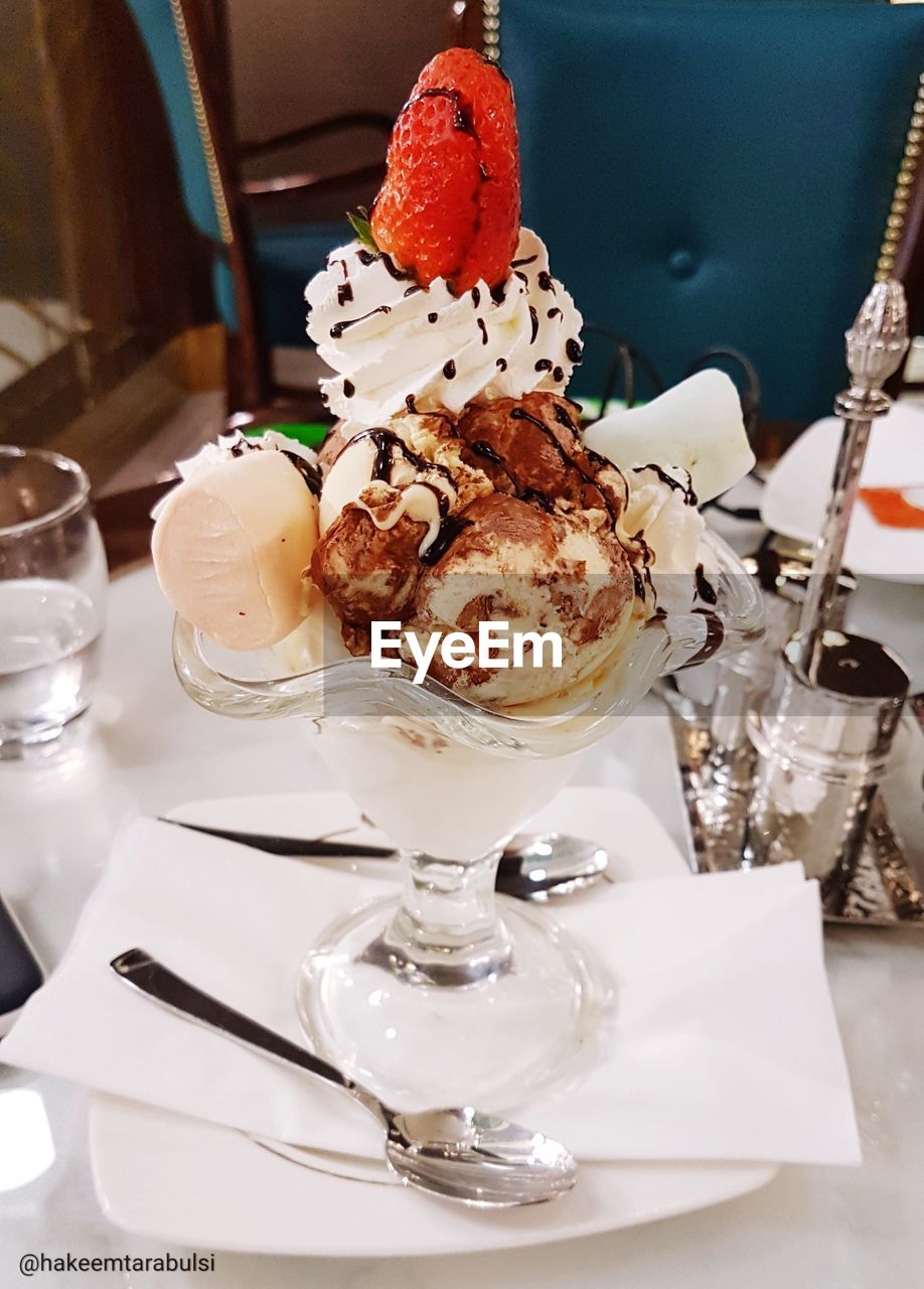 CLOSE-UP OF ICE CREAM WITH SPOON AND KNIFE ON TABLE