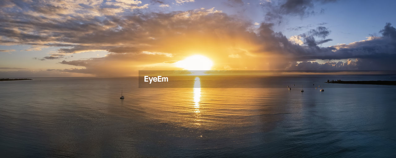 scenic view of sea against cloudy sky during sunset