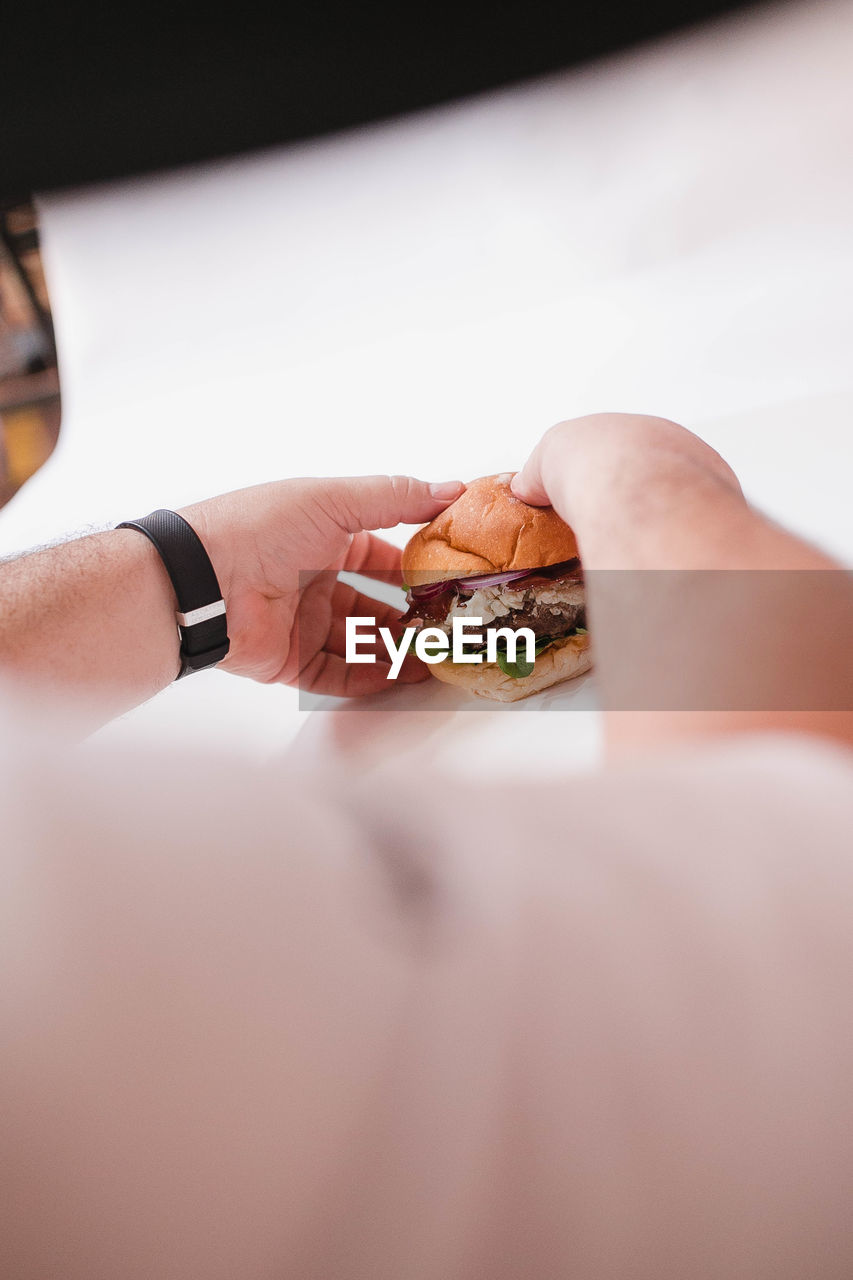 Close-up of hand preparing a burger